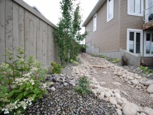A "Dry River Bed" was incorporated down the side of this "Starling at Big Lakes" walkout lot